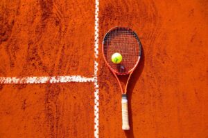 Racchetta di tennis appoggiata sulla terra rossa