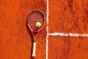 Racchetta di tennis appoggiata sulla terra rossa
